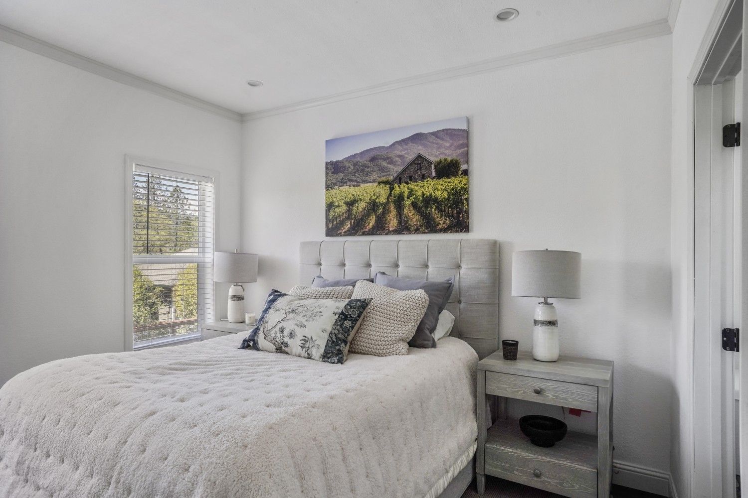 Perpetual Homes ADU: Cozy bedroom with a bed, nightstands, artwork, and a window.