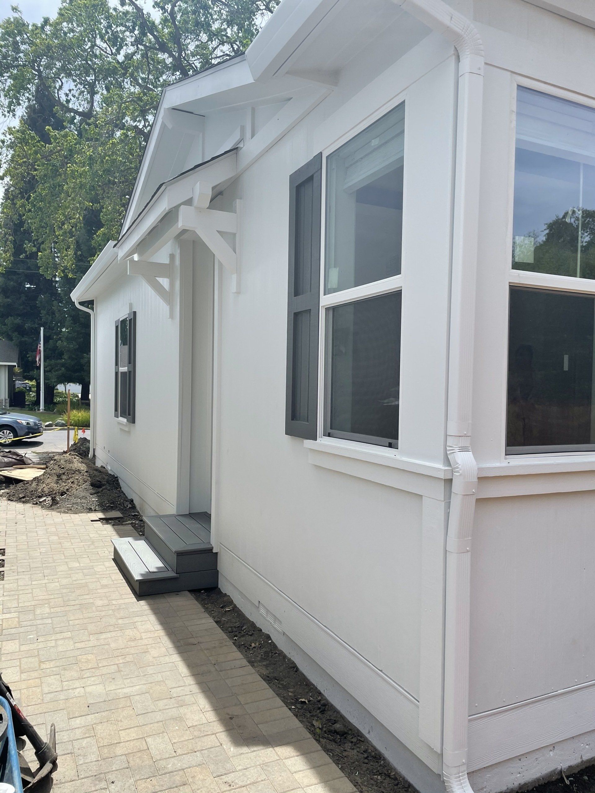 Perpetual Homes ADU: White house exterior with dark shutters and gray entry steps.