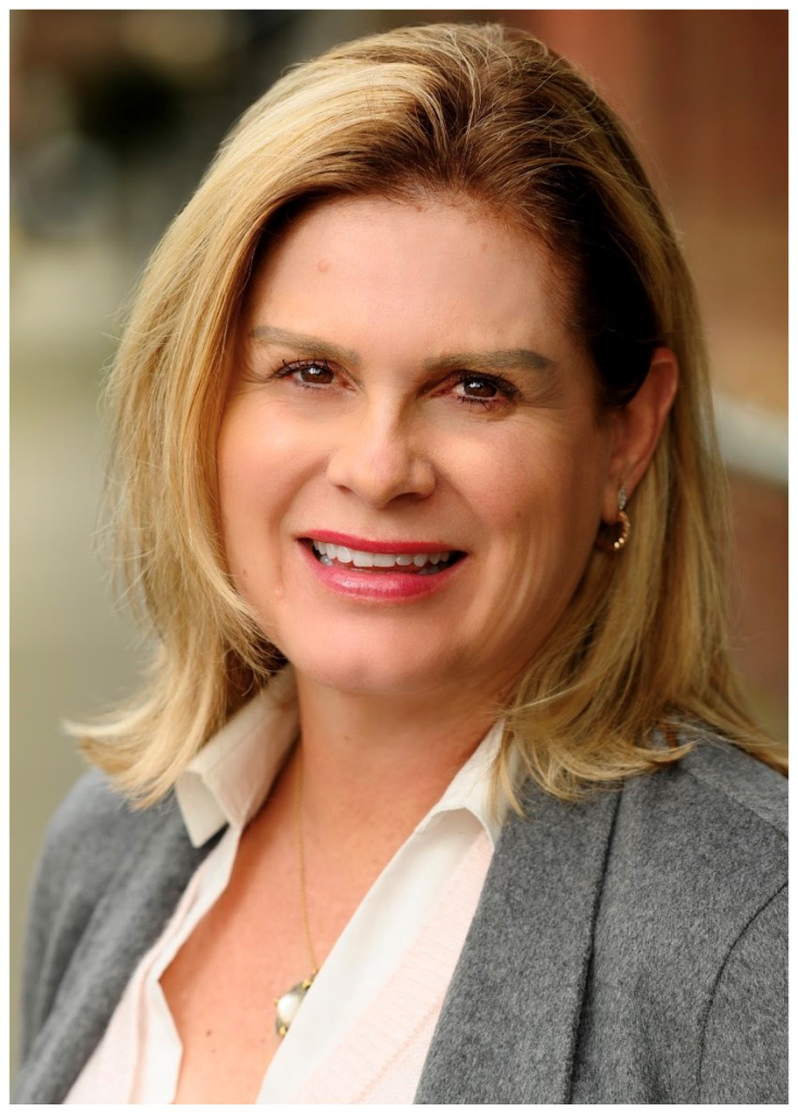 Katherine Anderson of Perpetual Homes ADU. Woman with blonde hair wearing a gray blazer and white shirt, smiling.