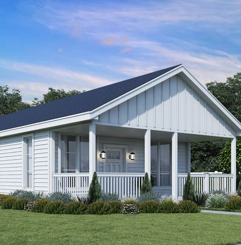 Perpetual Homes ADU: White house with front porch and dark blue roof, on a green lawn, under a blue sky.