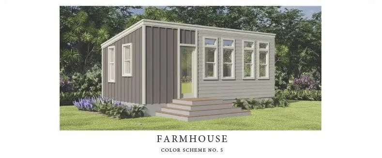 Perpetual Homes: A small ADU with gray siding, white-framed windows, green door, and small steps leading up to the entrance.