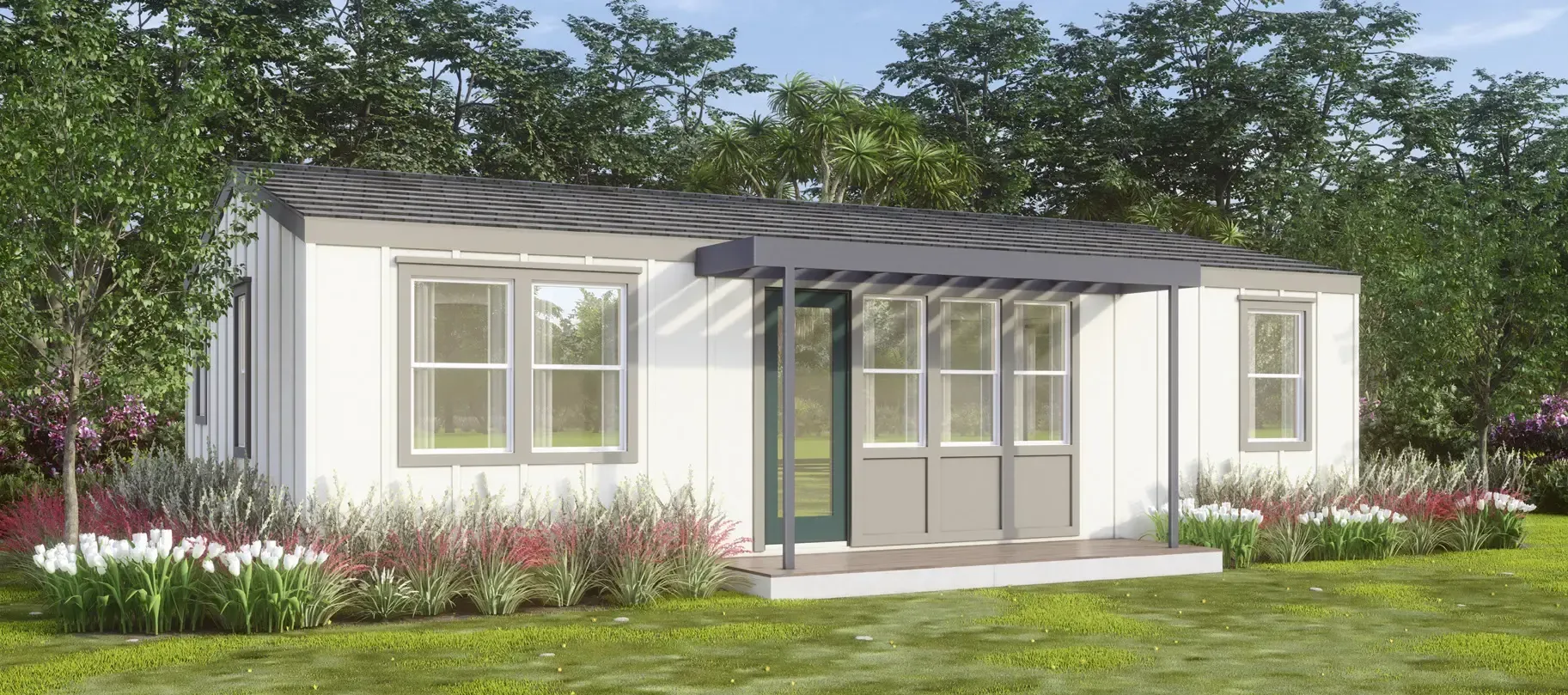 Perpetual Homes ADU: White modular home with gray roof and covered porch, set on a grassy lawn with trees in the background.
