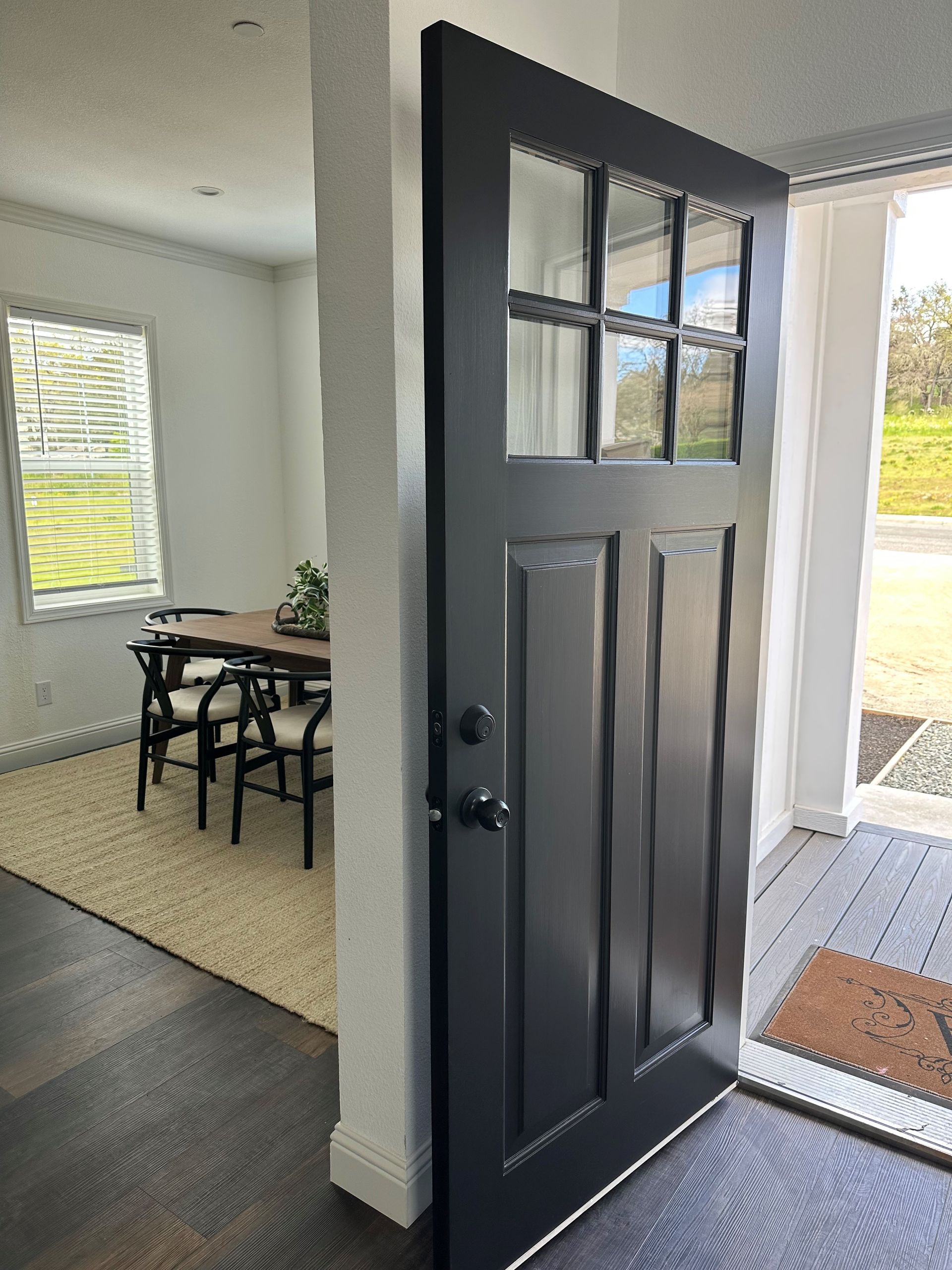 Perpetual Homes ADU: Black front door open, revealing dining area and entry porch.