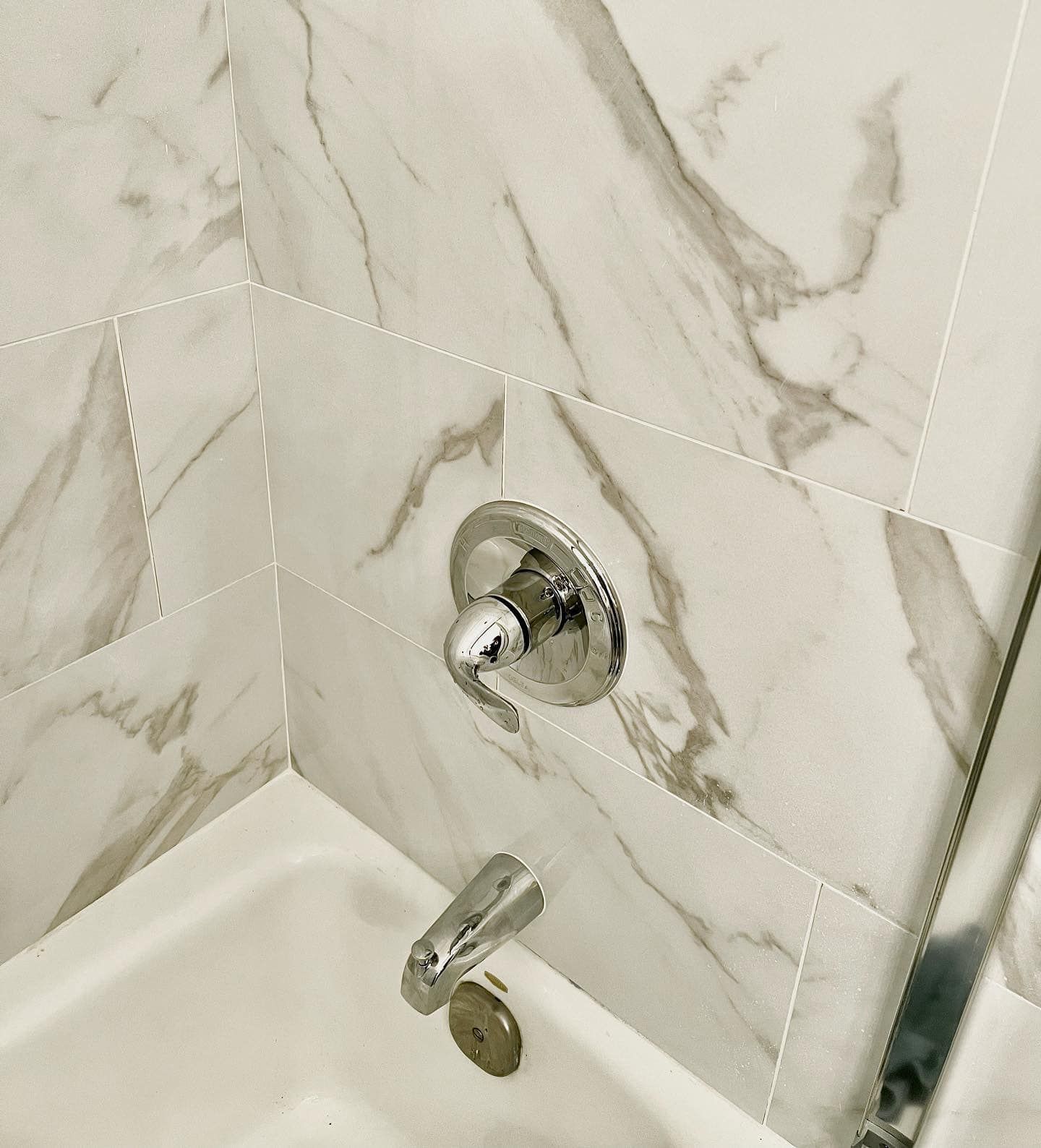 A bathroom with marble tiles and a bathtub