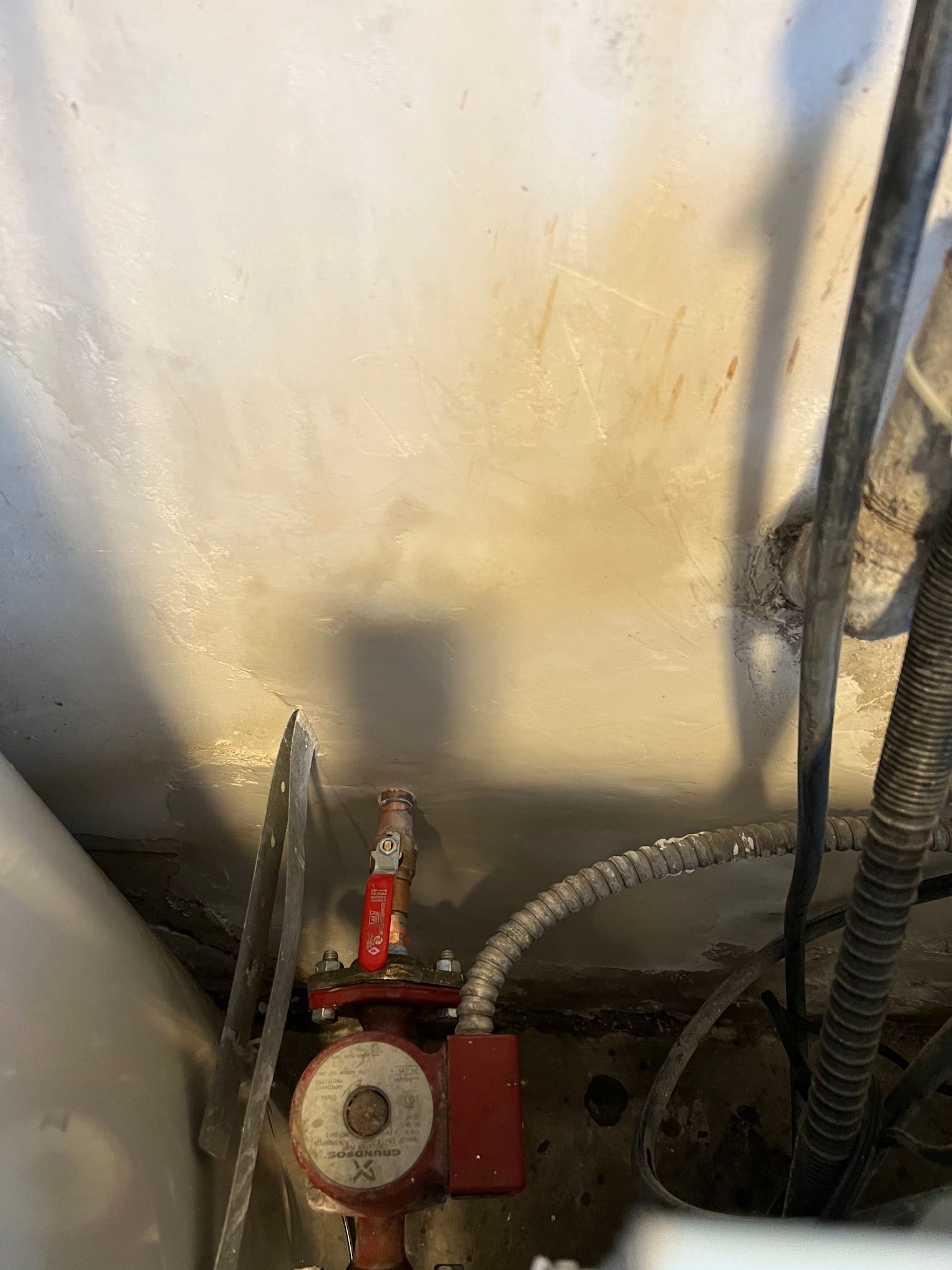 A close up of a water pump in a room next to a wall.