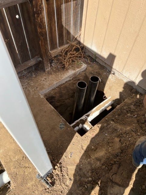 A hole in the ground with two pipes in it