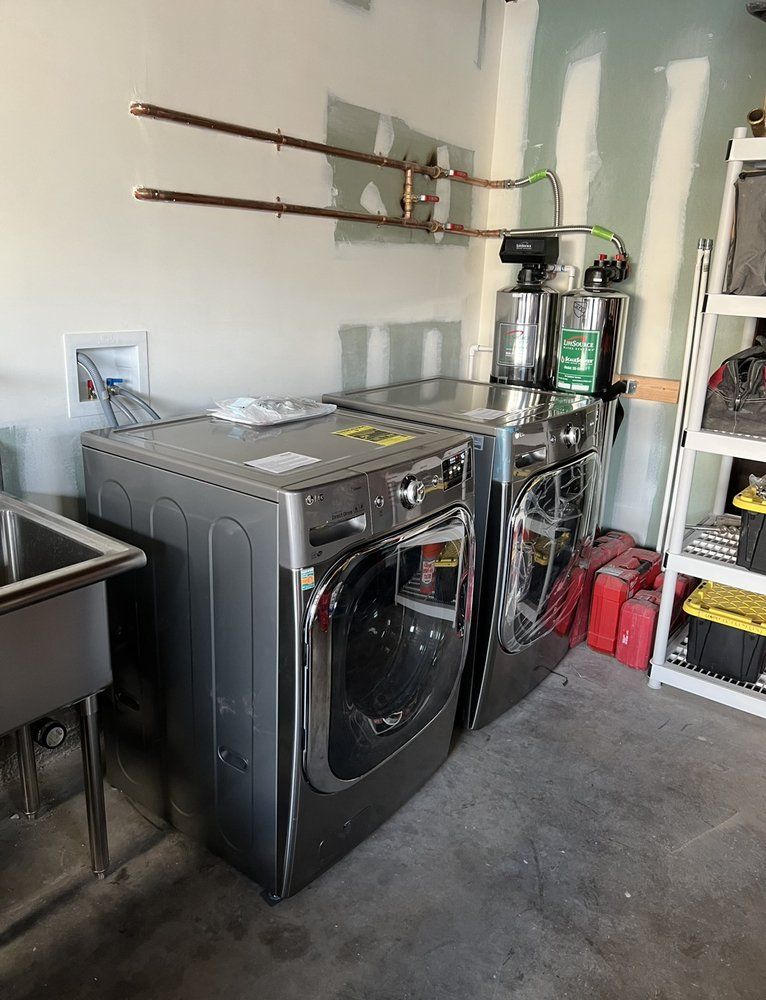 A laundry room with a washer and dryer and a sink.