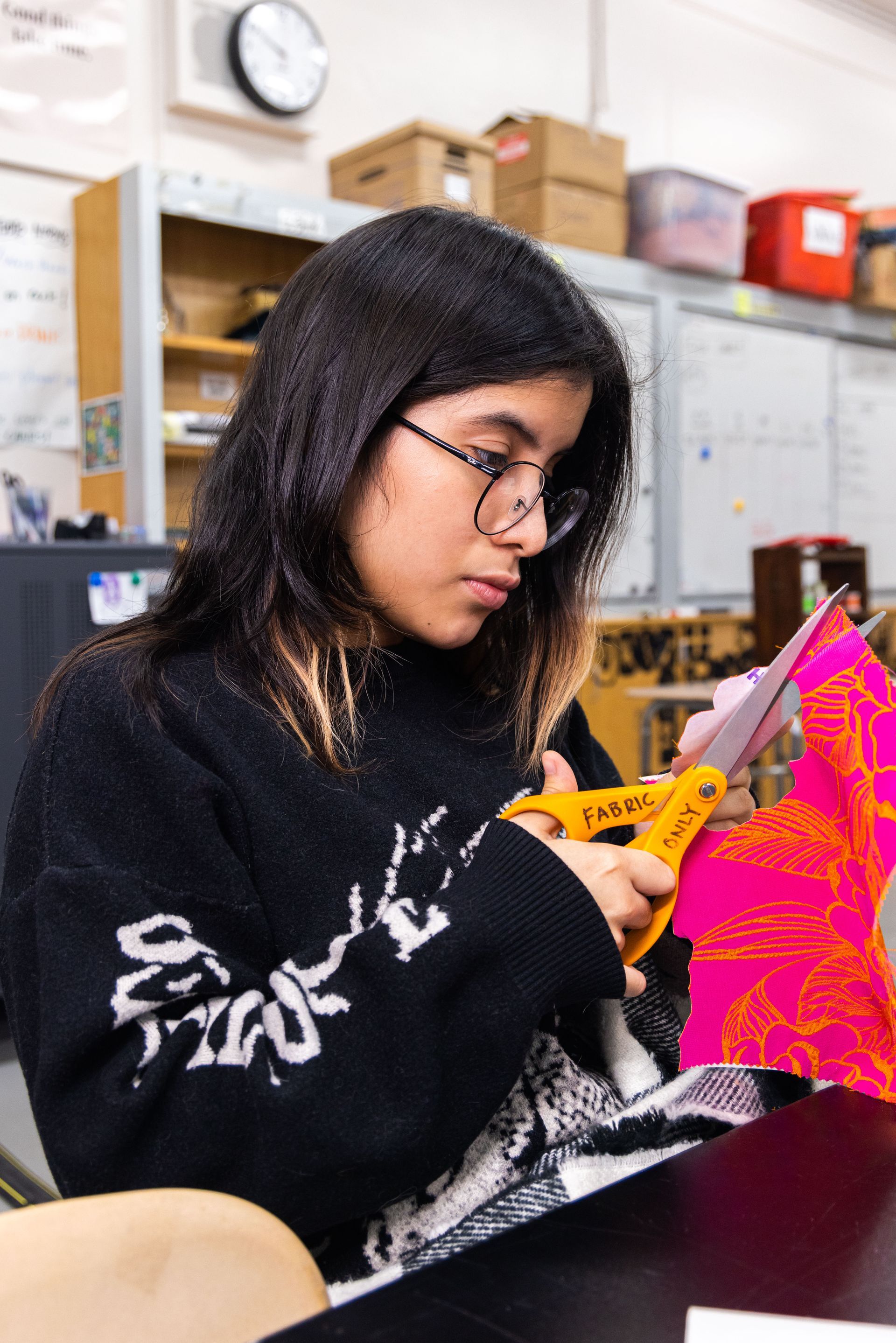 A student cutting fabric