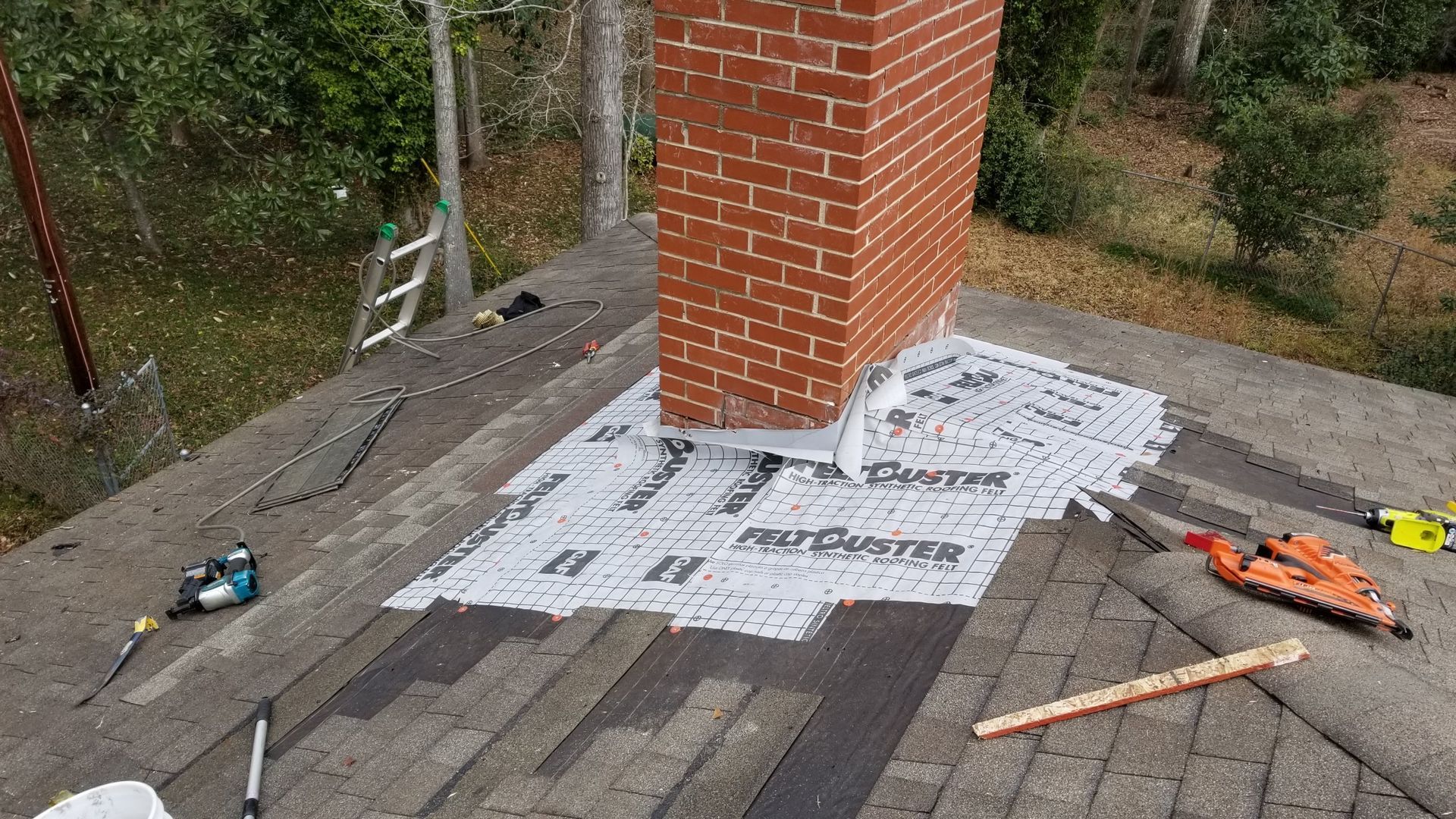 A brick chimney is sitting on top of a roof.