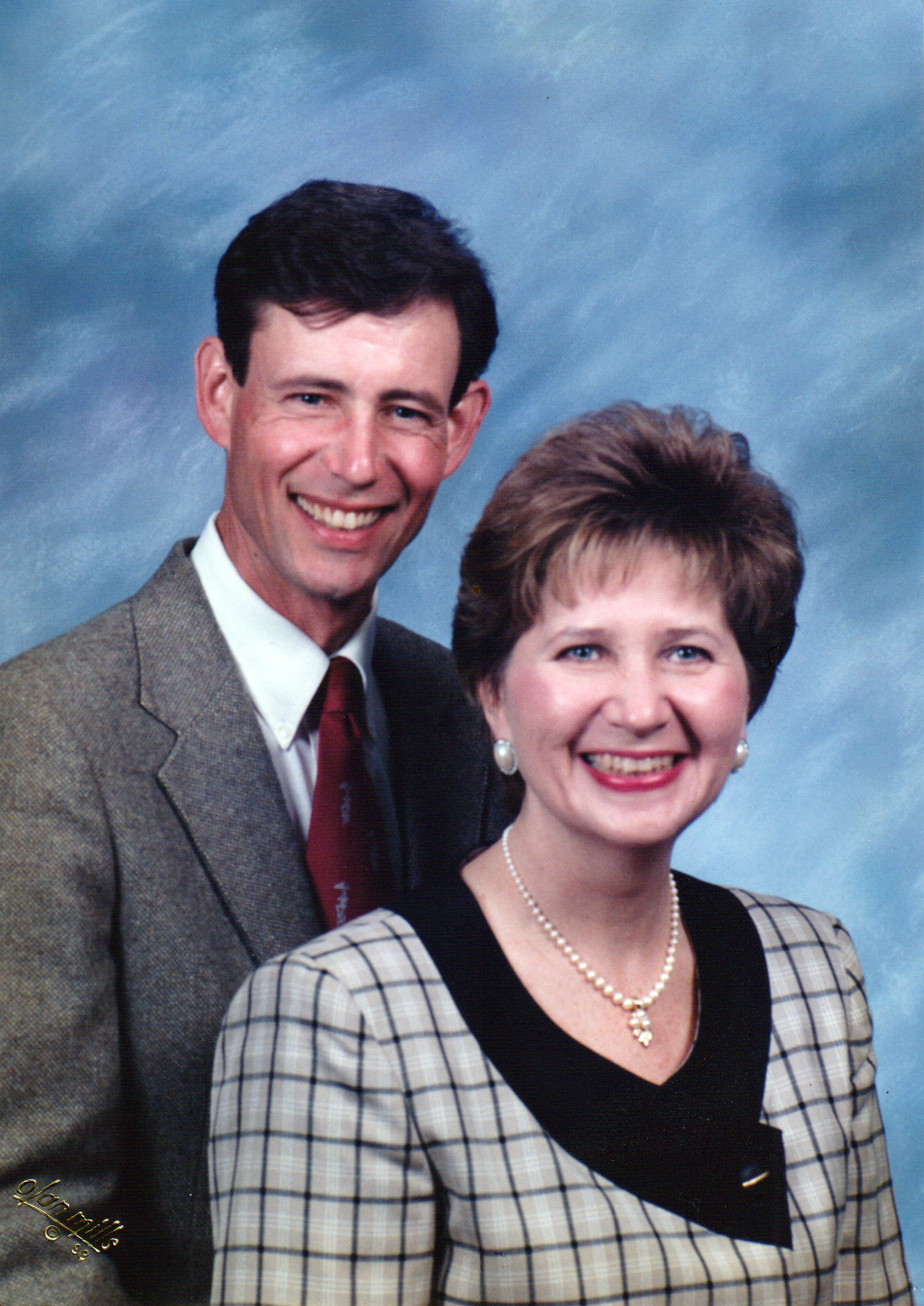 A man and a woman are posing for a picture and smiling