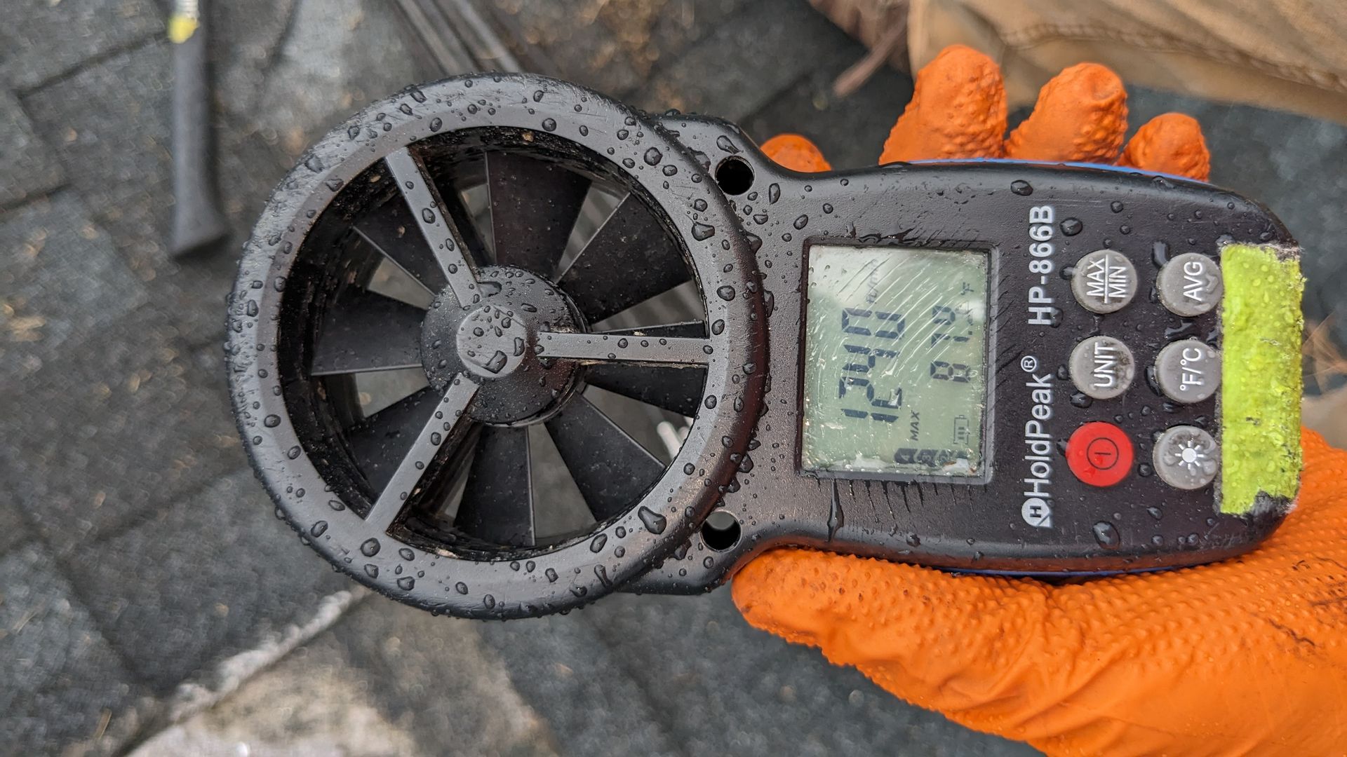 A person is holding a wind meter in their hand.