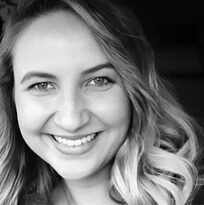 A black and white photo of a woman smiling.