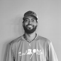 A man with a beard is wearing a hat and a shirt.