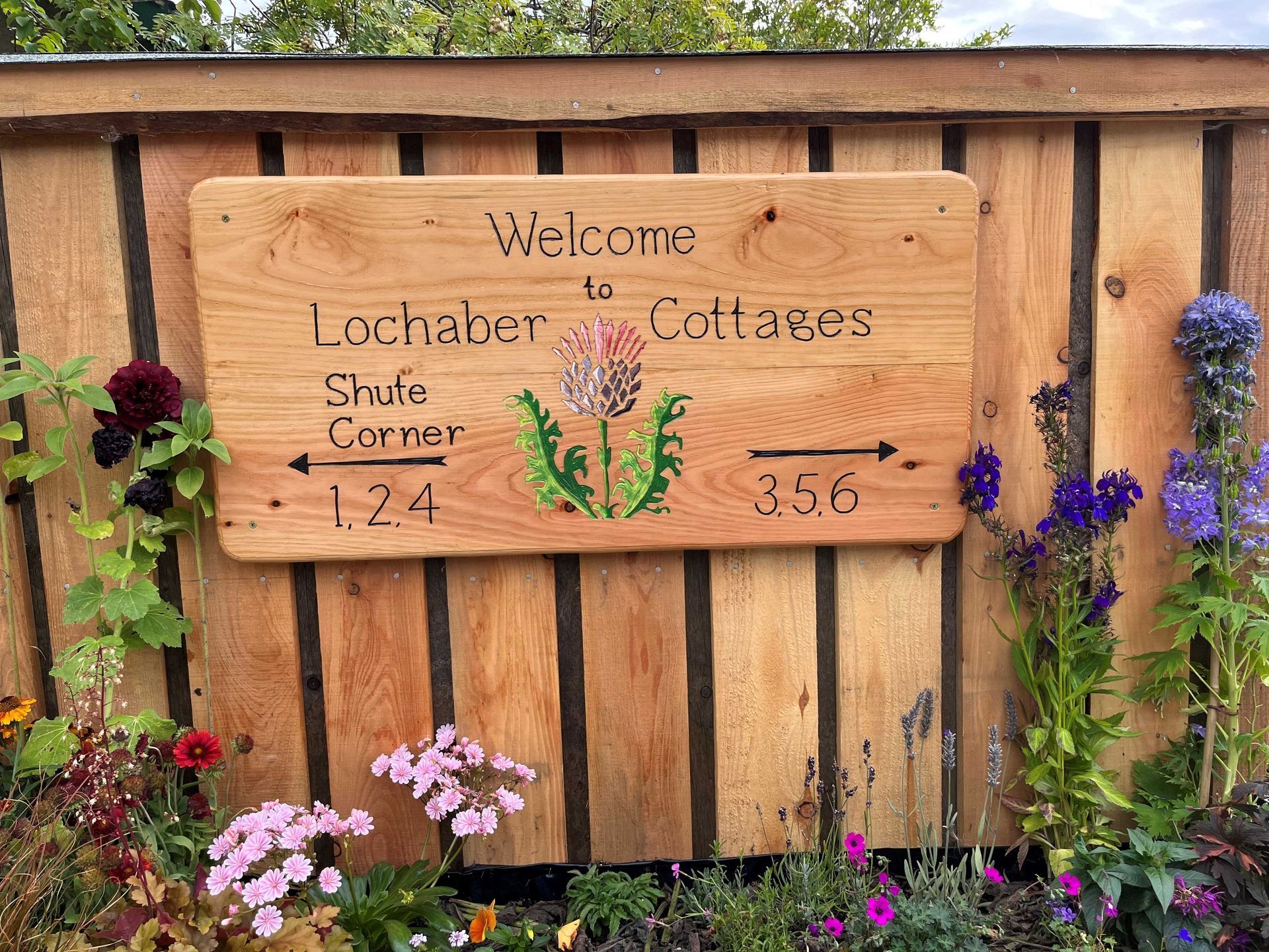 Wooden house sign with a picture made by Ingrained Culture