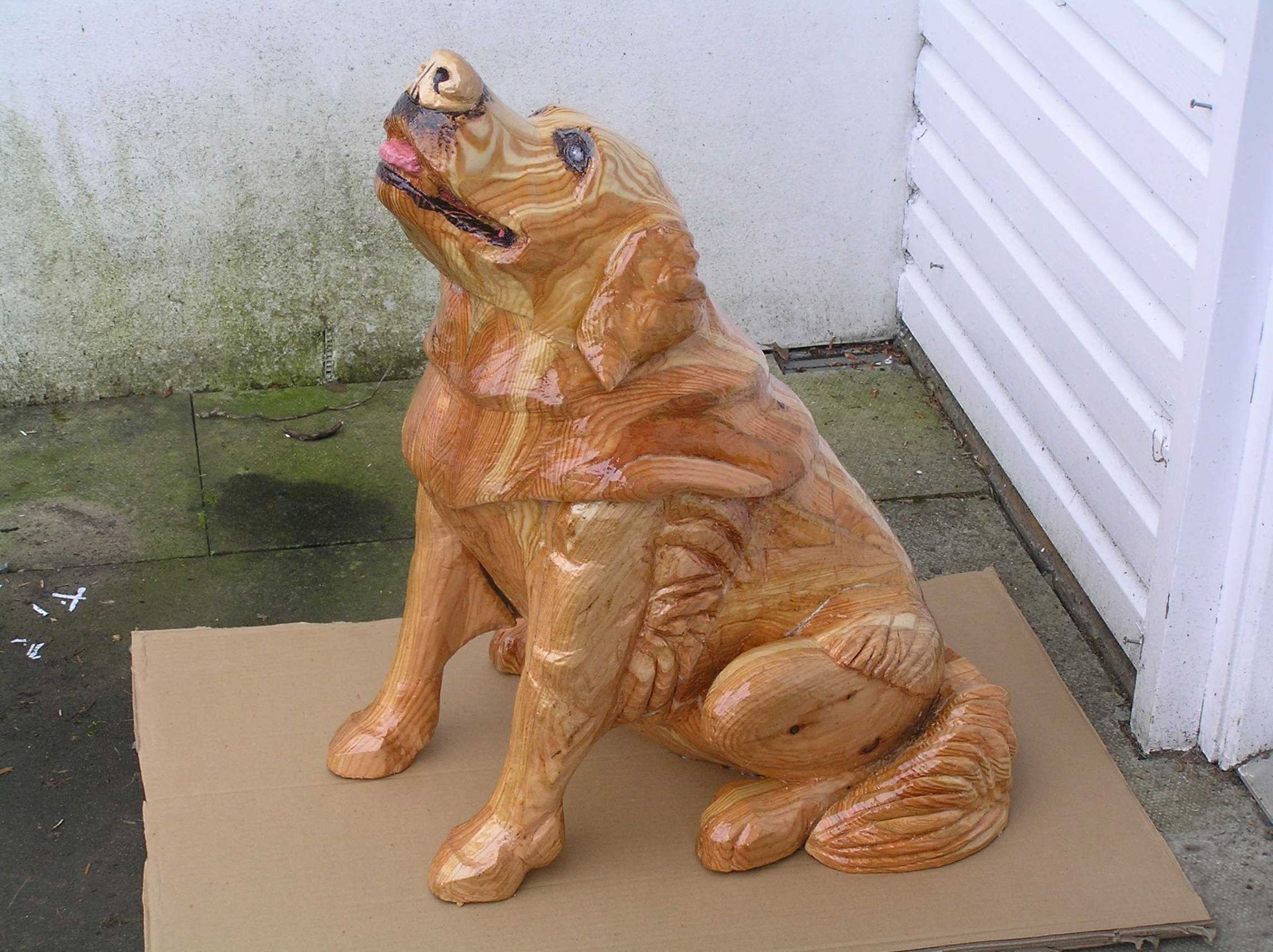 a sitting dog sculpture made from wood by ingrained culture