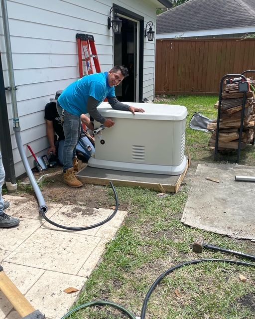 Worker installing a white generator beside a house, with tools and a ladder nearby.