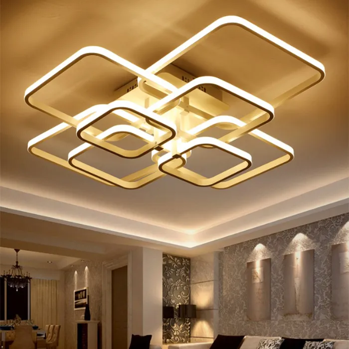 Modern living room ceiling with a gold geometric LED light fixture and recessed wall lighting