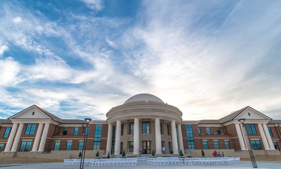 a large building with white chairs in front of it