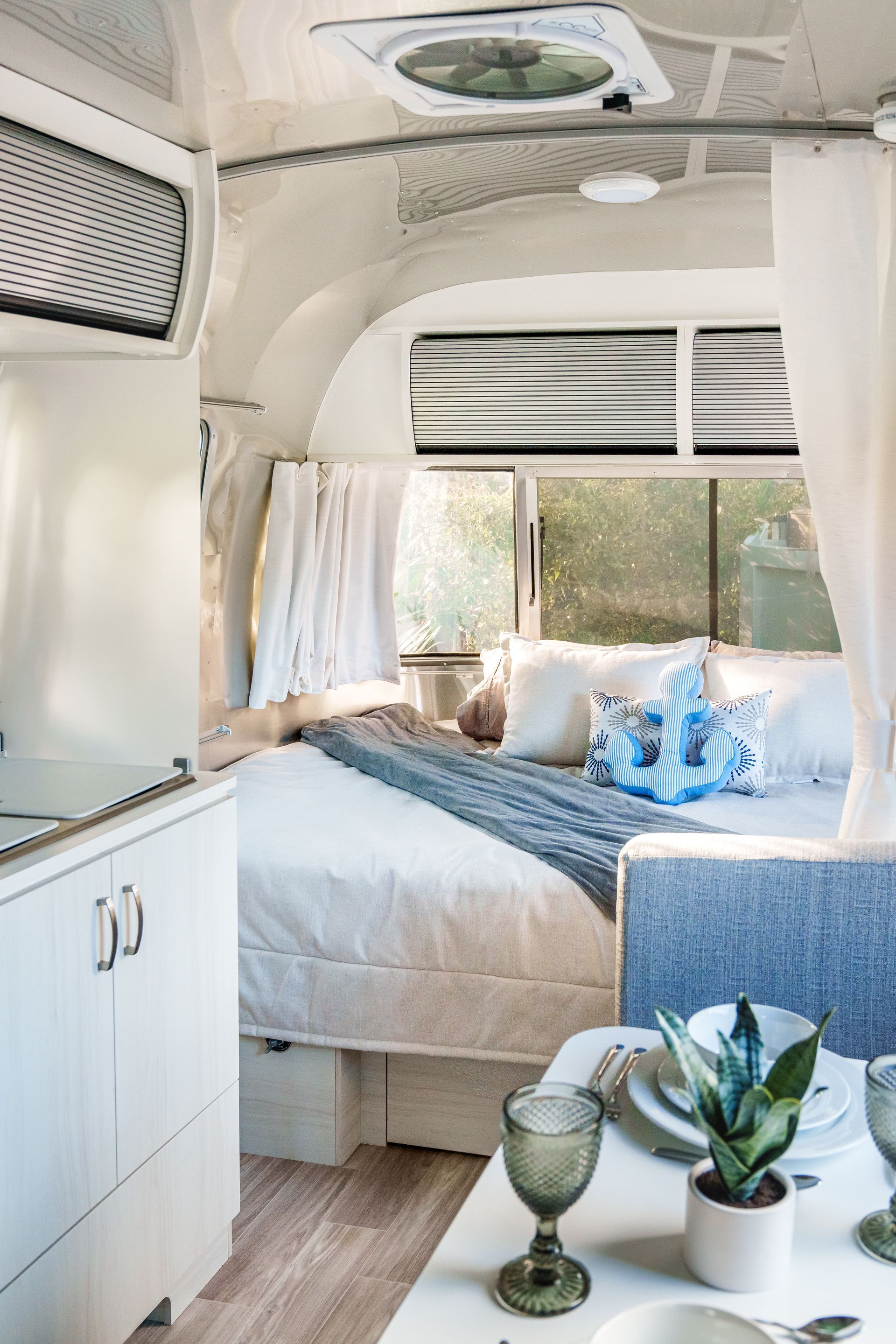 Interior RV bedroom styled with coastal-inspired linens
