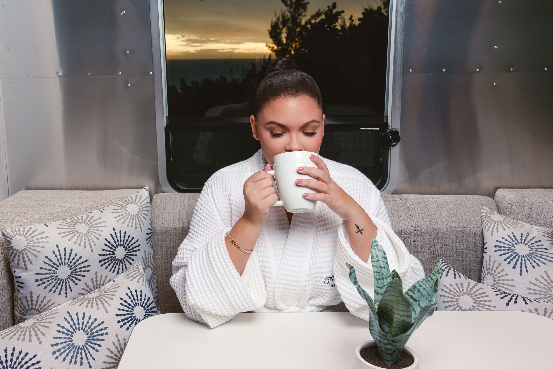 Woman enjoying morning coffee inside a cozy RV in Bermuda
