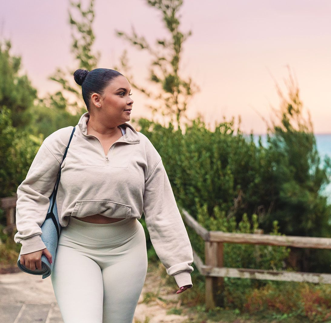Woman hiking along Bermuda coastal trail near eco-RV site