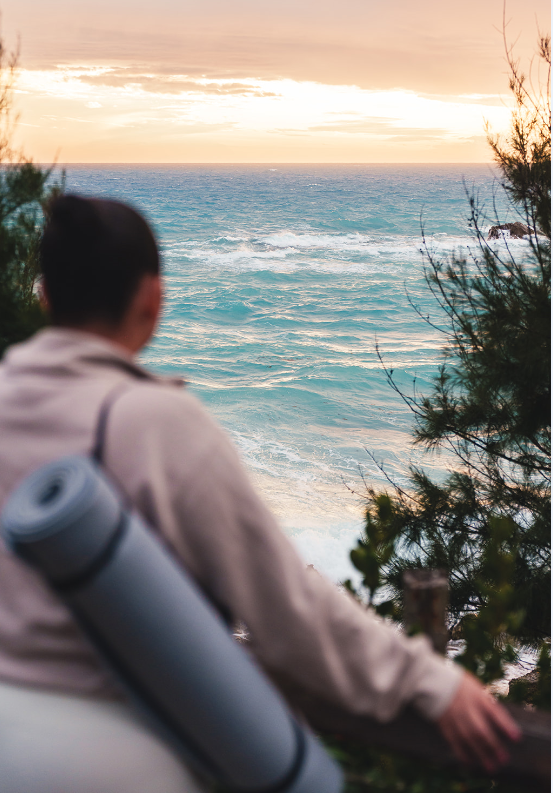 Back view of woman gazing at Bermuda sunrise over ocean