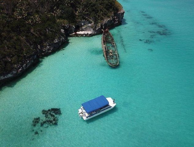 An aerial view of a boat in the ocean near a small island