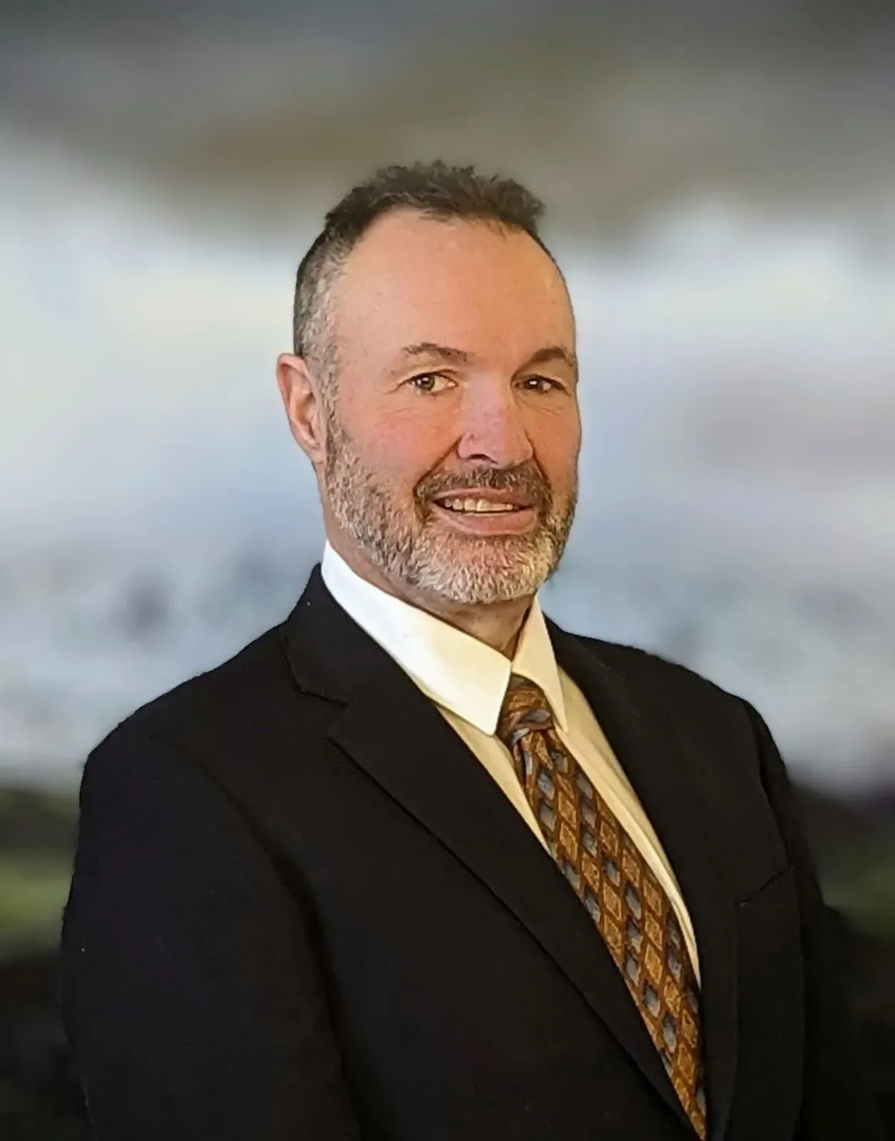 A man with a short beard wearing a dark suit