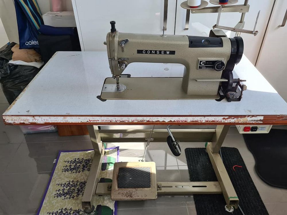 A Sewing Machine is Sitting on a White Table — James Hunter Mobile Sewing Machine Mechanic in Battery Hill, QLD