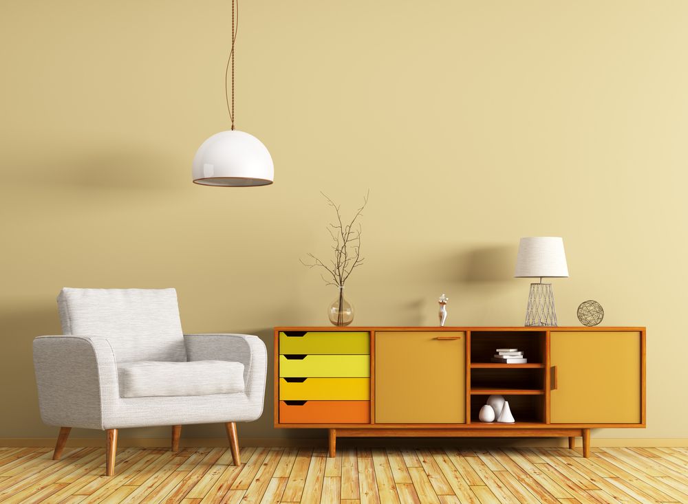 Uma sala de estar com uma cadeira, cômoda e luminária.