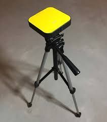 A tripod with a yellow object on top of it.
