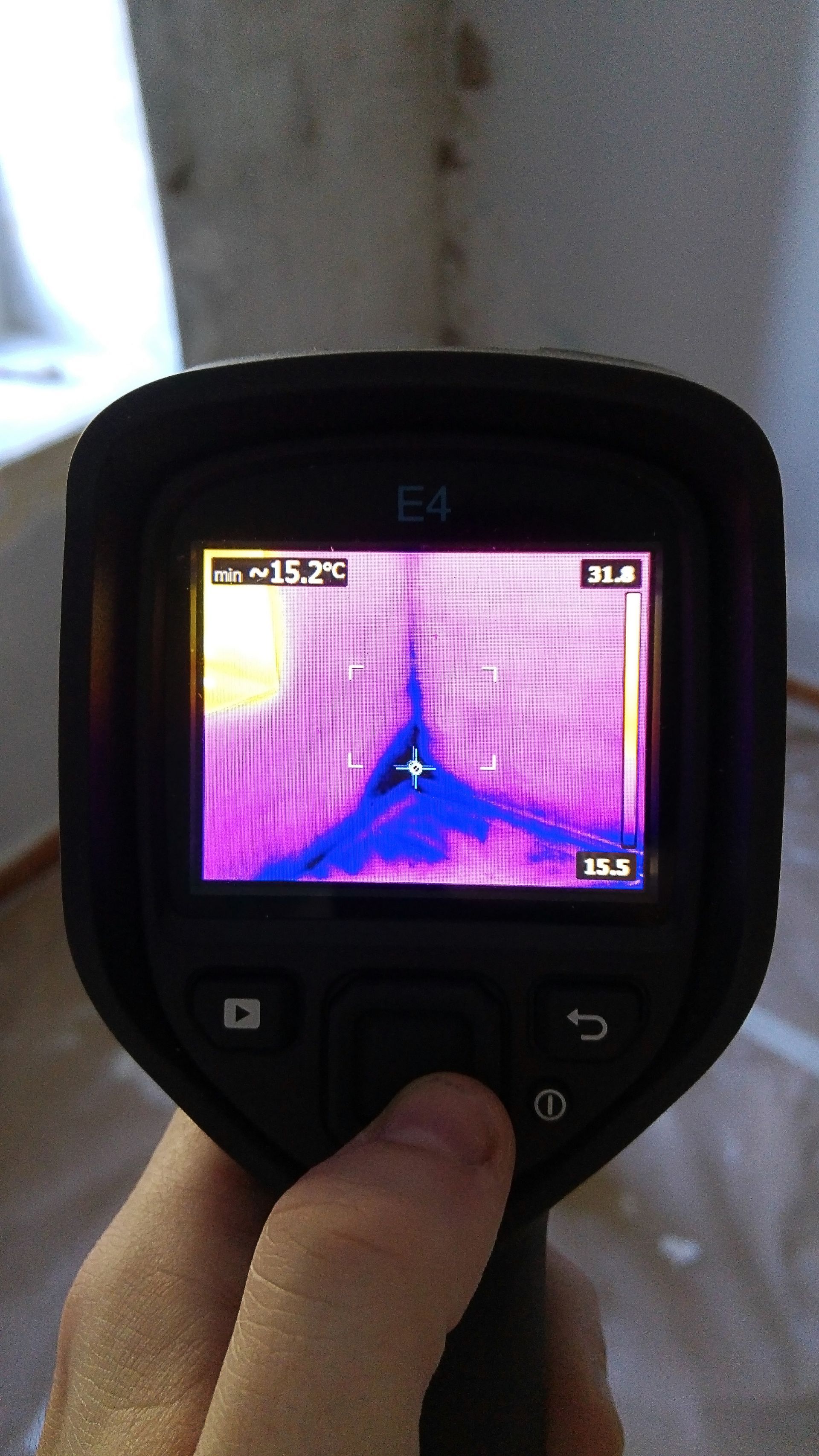 A person is holding a thermal camera in their hand.