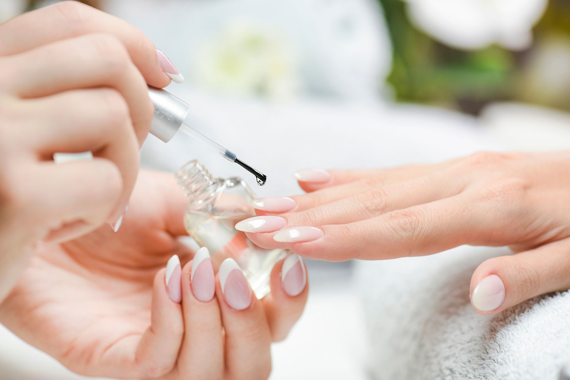 Person getting a manicure; red nail polish applied in a well-lit setting. Person getting a manicure; red nail polish applied in a well-lit setting.