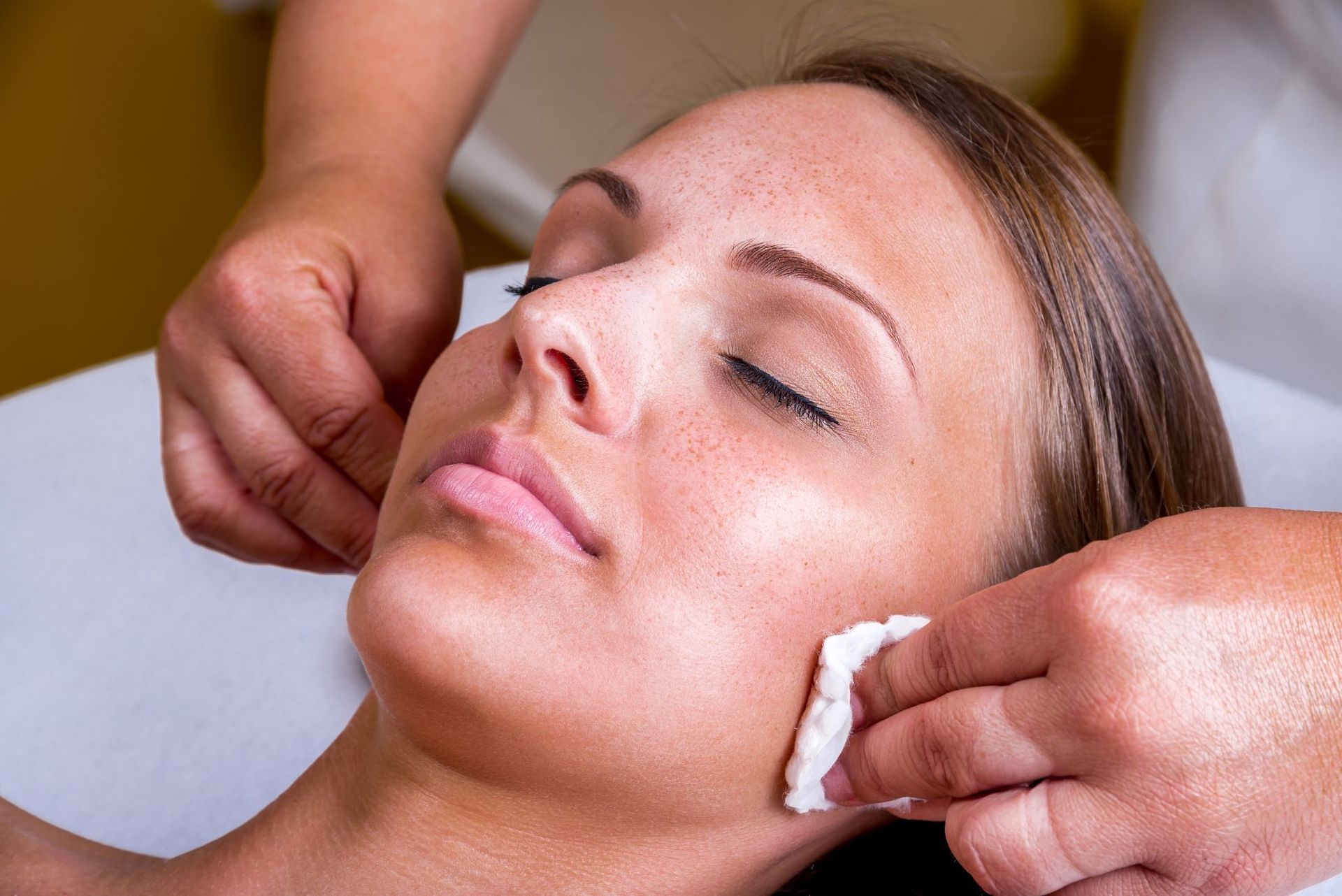 A woman is getting a facial treatment at a spa.