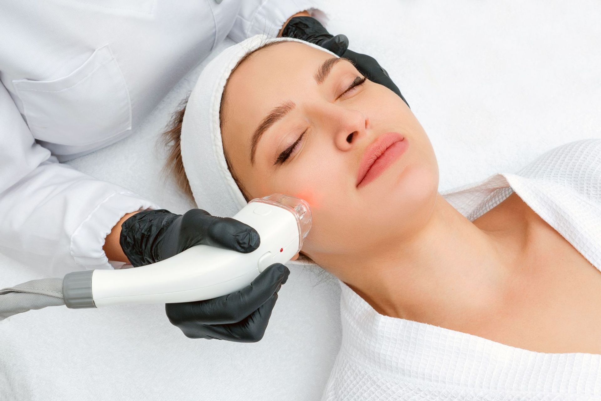 A woman is getting a facial treatment at a beauty salon.