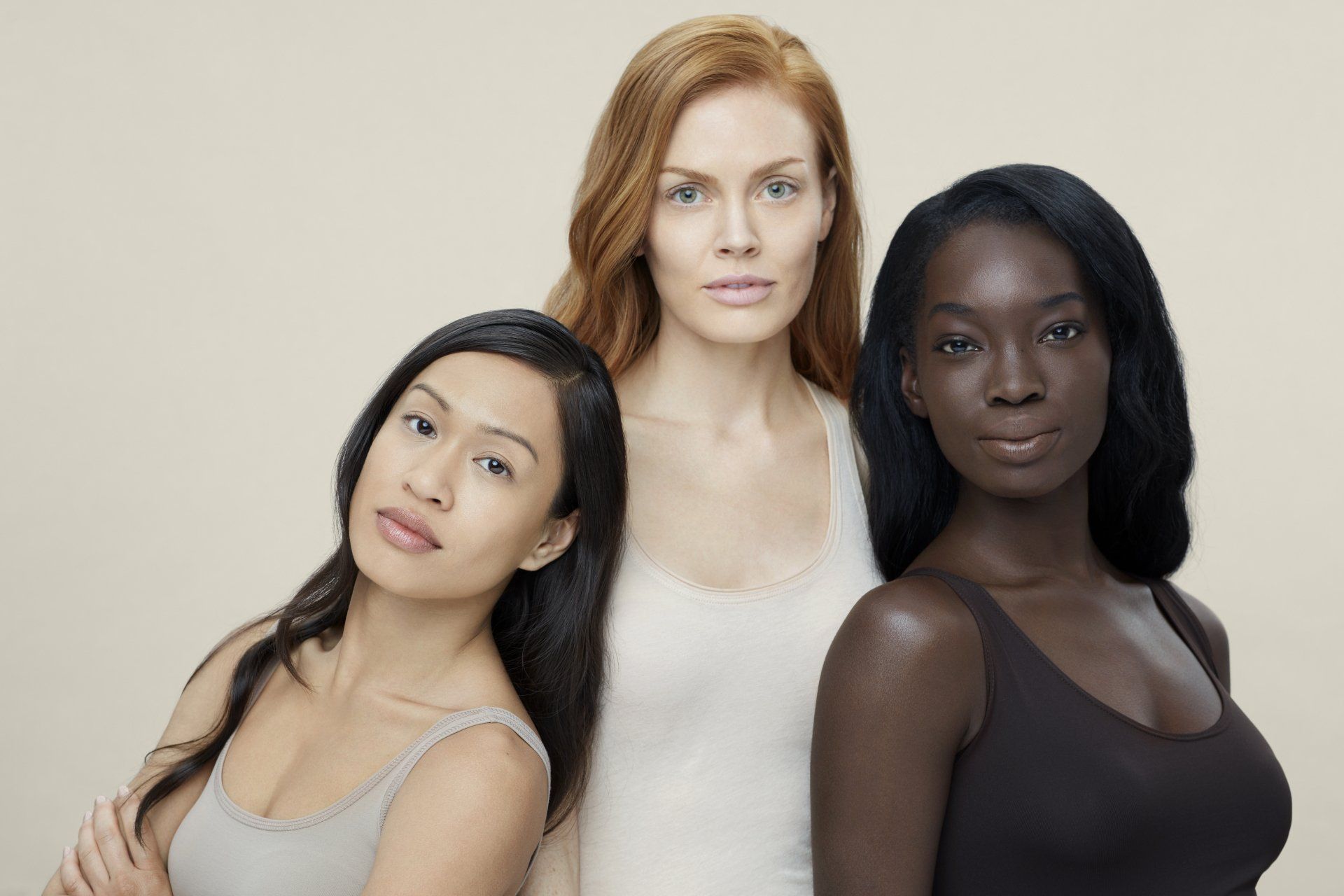 Three women of different races are posing for a picture together