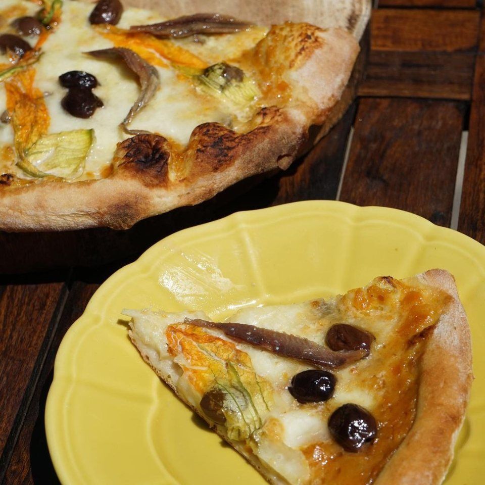Pizza con olive nere e fiori di zucca