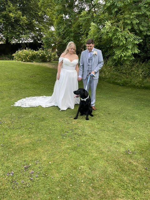Bride and groom and two Beagles at Sandburn Hall in rose garden
