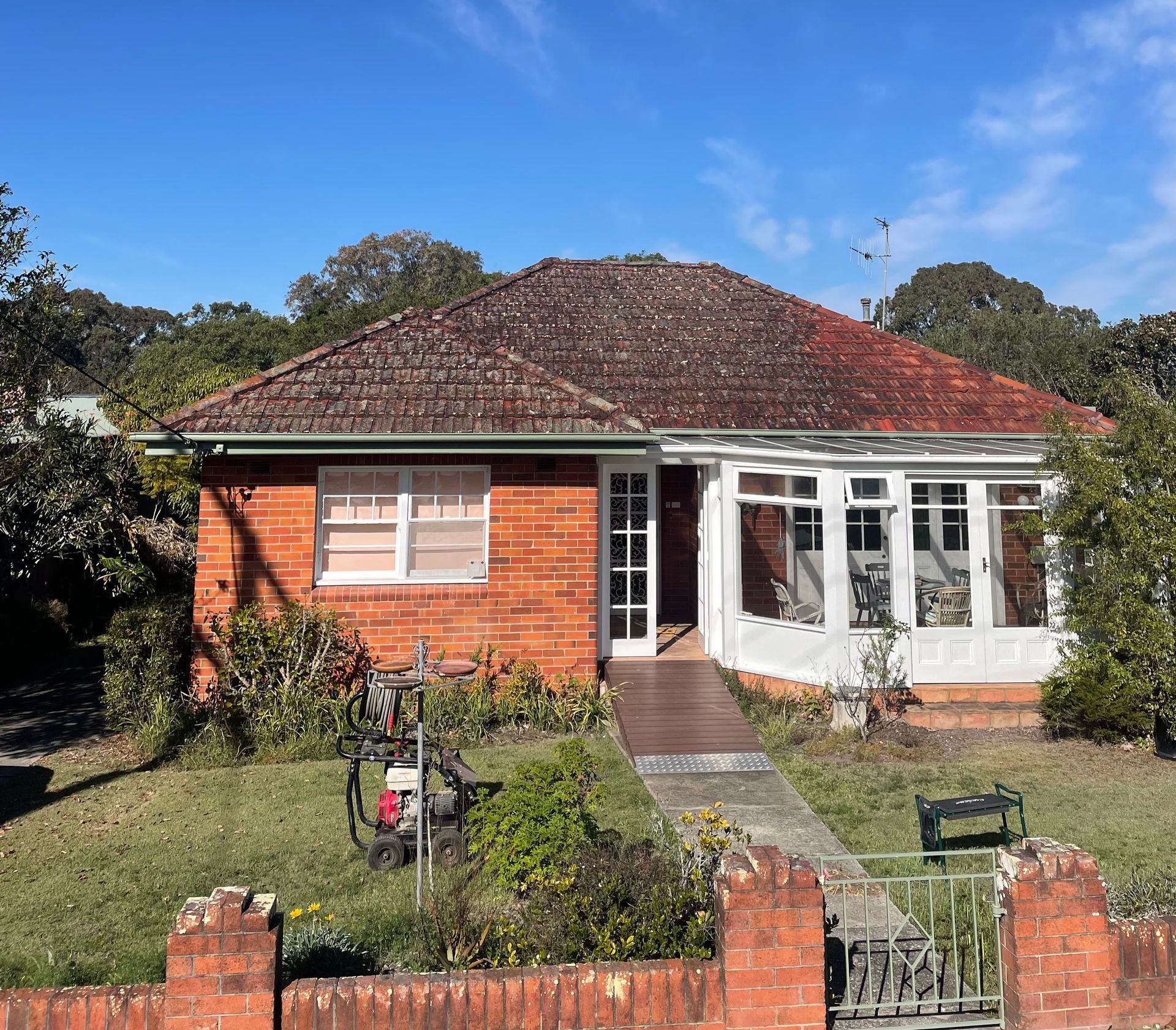 A Small Brick House with A Red Roof and White Trim Before — Bulley Roof Restoration, Painting & Pressure Cleaning in Wingham, NSW