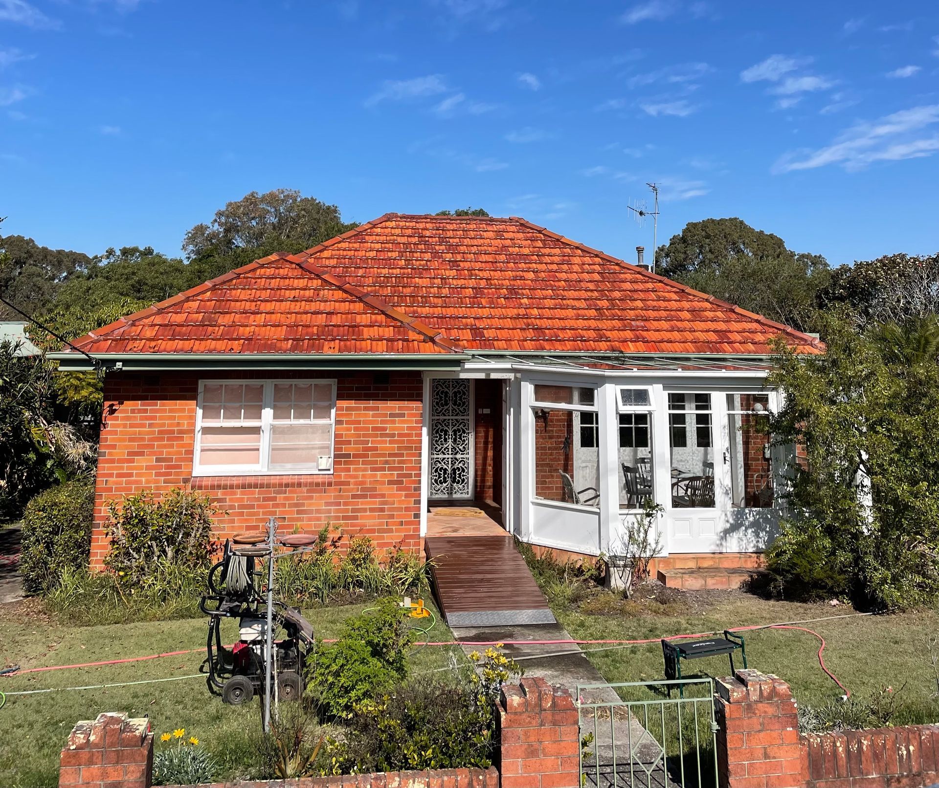 A Small Brick House with A Red Tile Roof After — Bulley Roof Restoration, Painting & Pressure Cleaning in Wingham, NSW