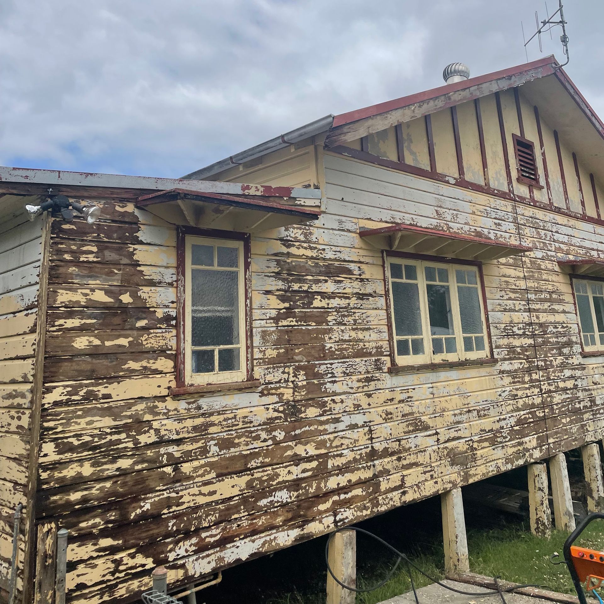 An Old Wooden House with Peeling Paint and A Red Roof Before — Bulley Roof Restoration, Painting & Pressure Cleaning in Wingham, NSW