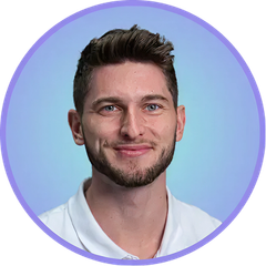 Man with a beard smiling, in a white shirt, inside a purple circle, on a blue background.