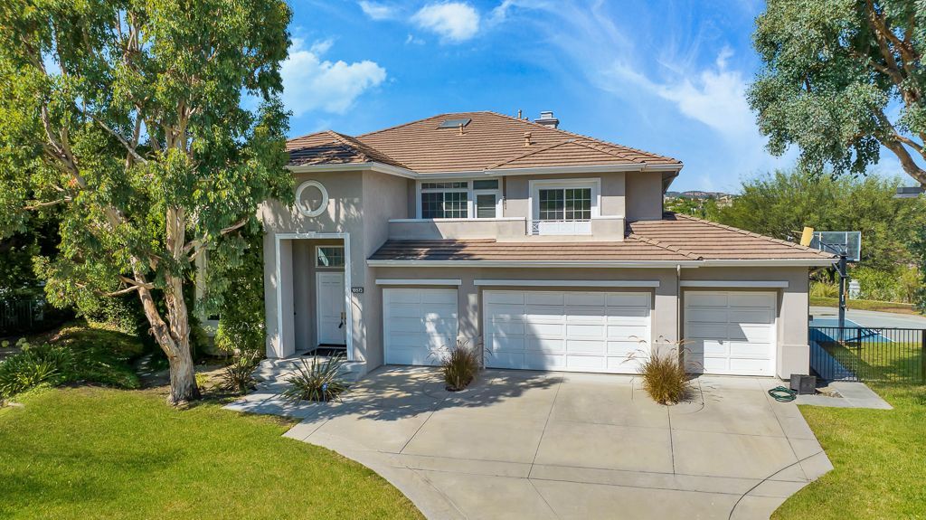 A large house with two garages and a driveway is for sale.