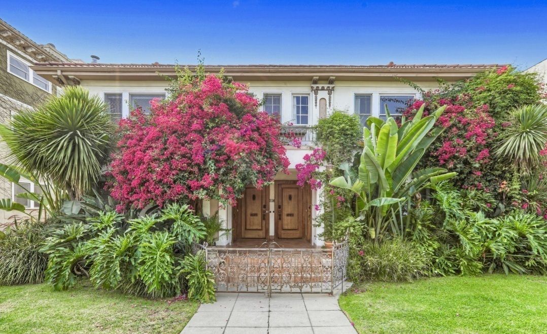 A house with a lot of flowers in front of it.