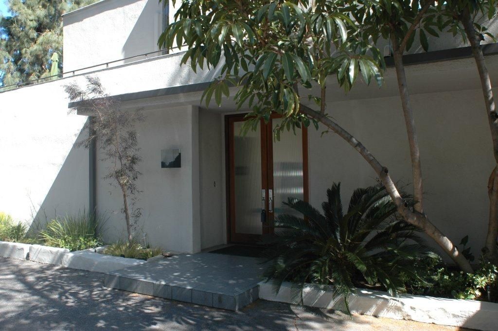 A white building with a tree in front of it