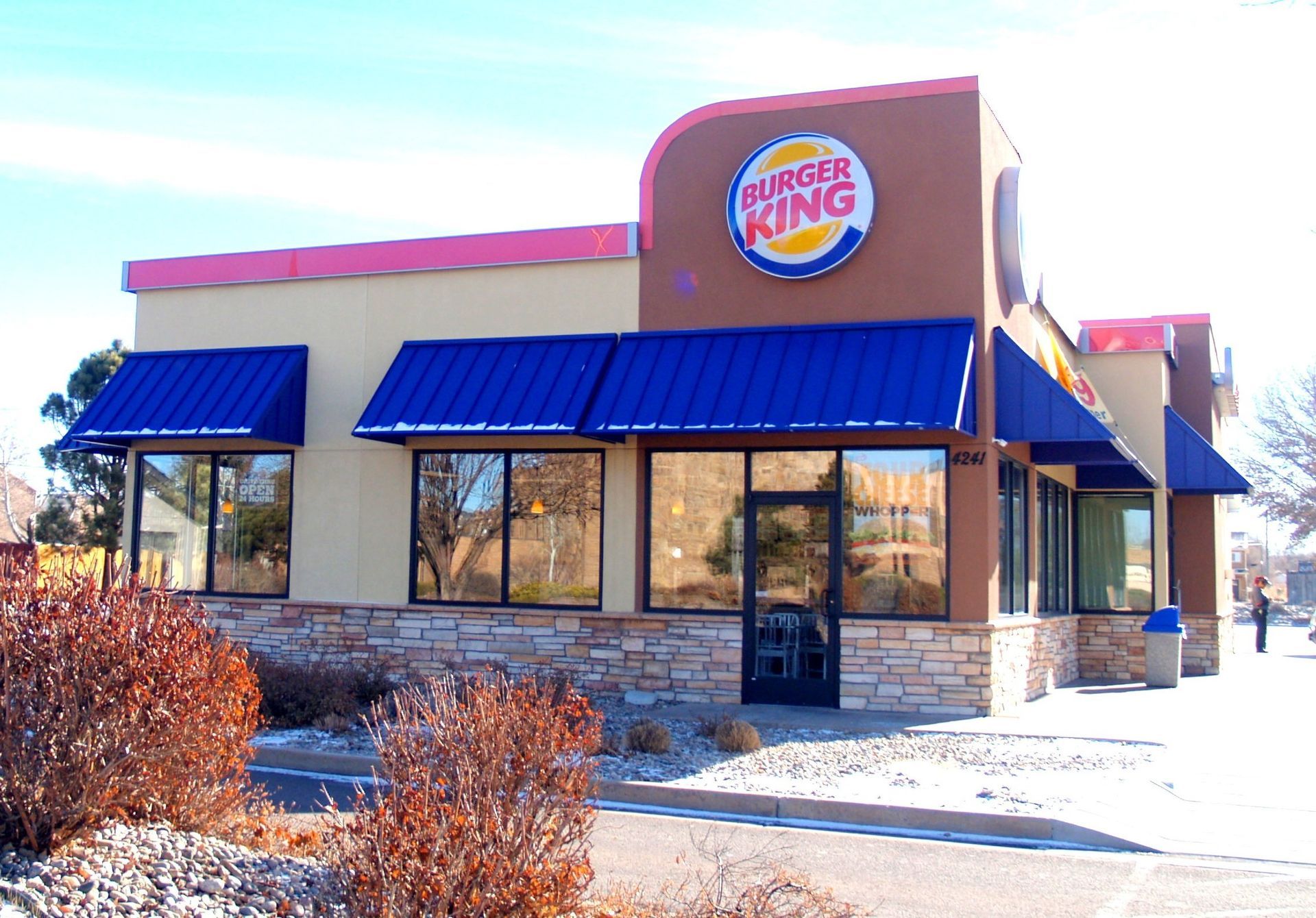 A burger king restaurant with a blue awning