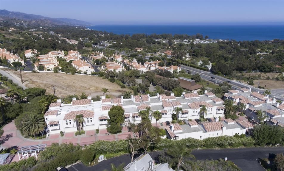 An aerial view of a residential area next to the ocean.