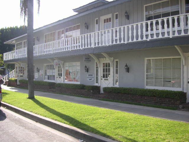 A building with a balcony and a lawn in front of it