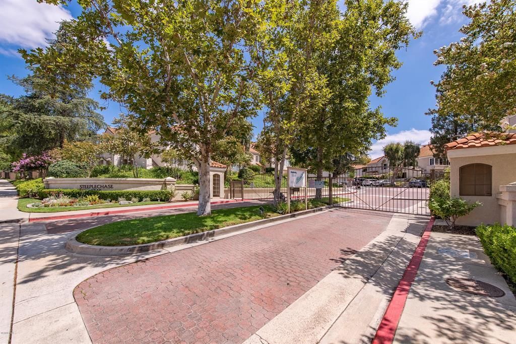 A residential street with trees and a red curb