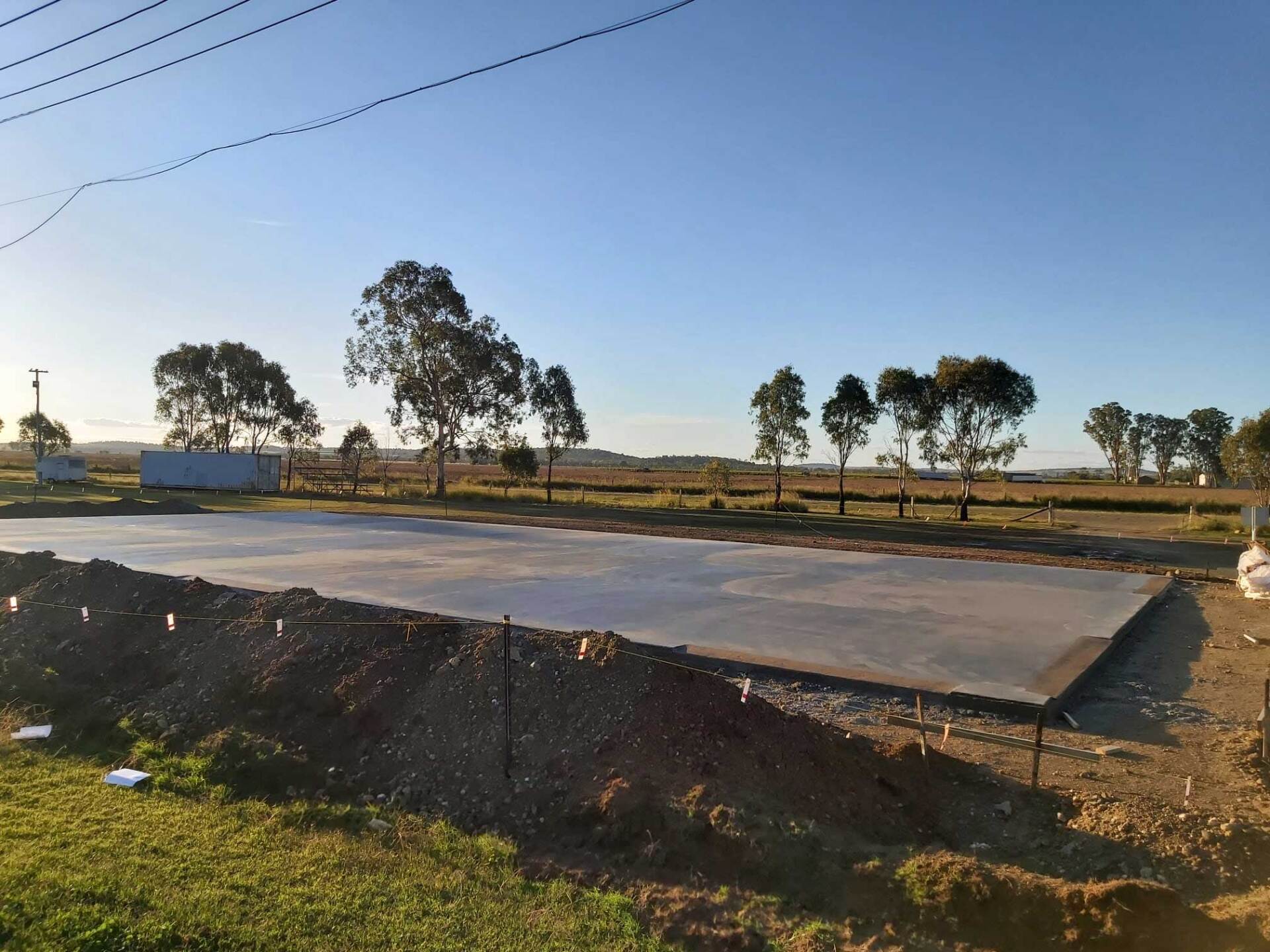 A large concrete slab is sitting in the middle of a field with trees in the background.